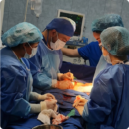 Cirujano realizando cirugía oncológica mínimamente invasiva con equipo especializado en quirófano.